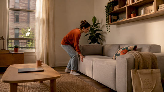 Woman arranging furniture in small apartment living room