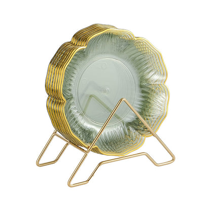 Stack of green glass plates with gold rim and stand on a white background