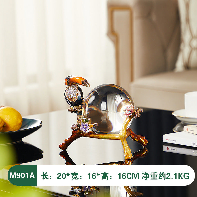 Decorative object with a bird and sphere design on a table