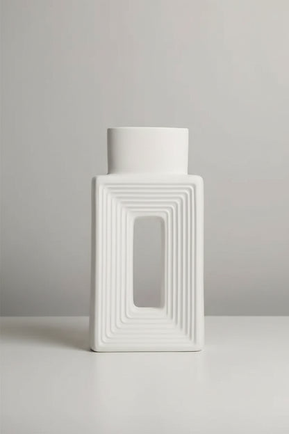 A white rectangular ceramic vase with concentric square ridges and a central rectangular cutout, shown on a beige background with a small text overlay detailing its dimensions.