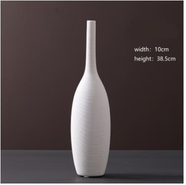 White ceramic vase on a dark surface with a brown background