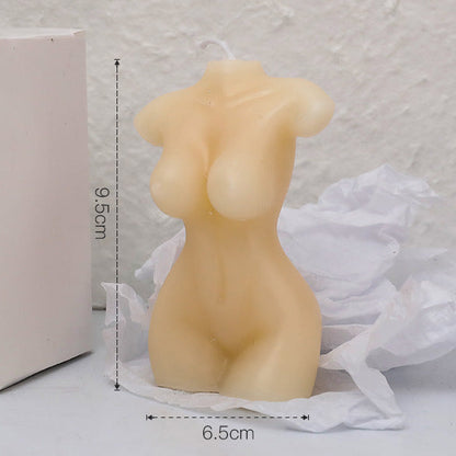 Candle shaped like a female torso with measurements on a textured surface