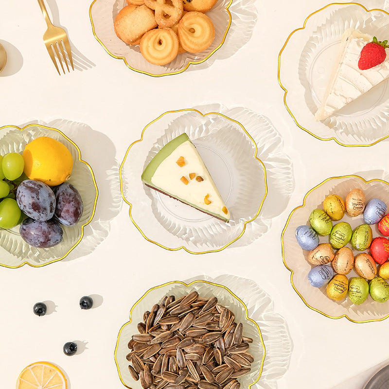 Assorted food items on white plates with gold rims on a light beige background