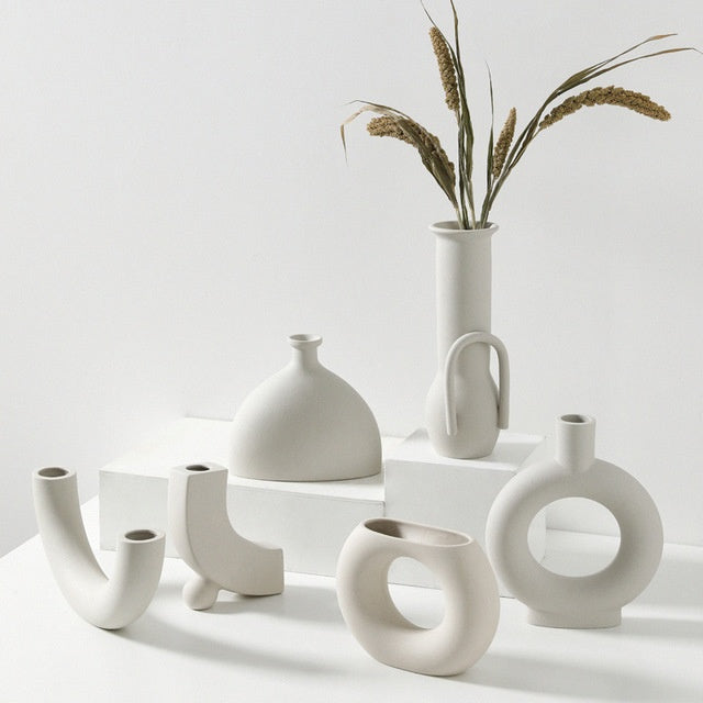 Collection of white ceramic vases on a light background
